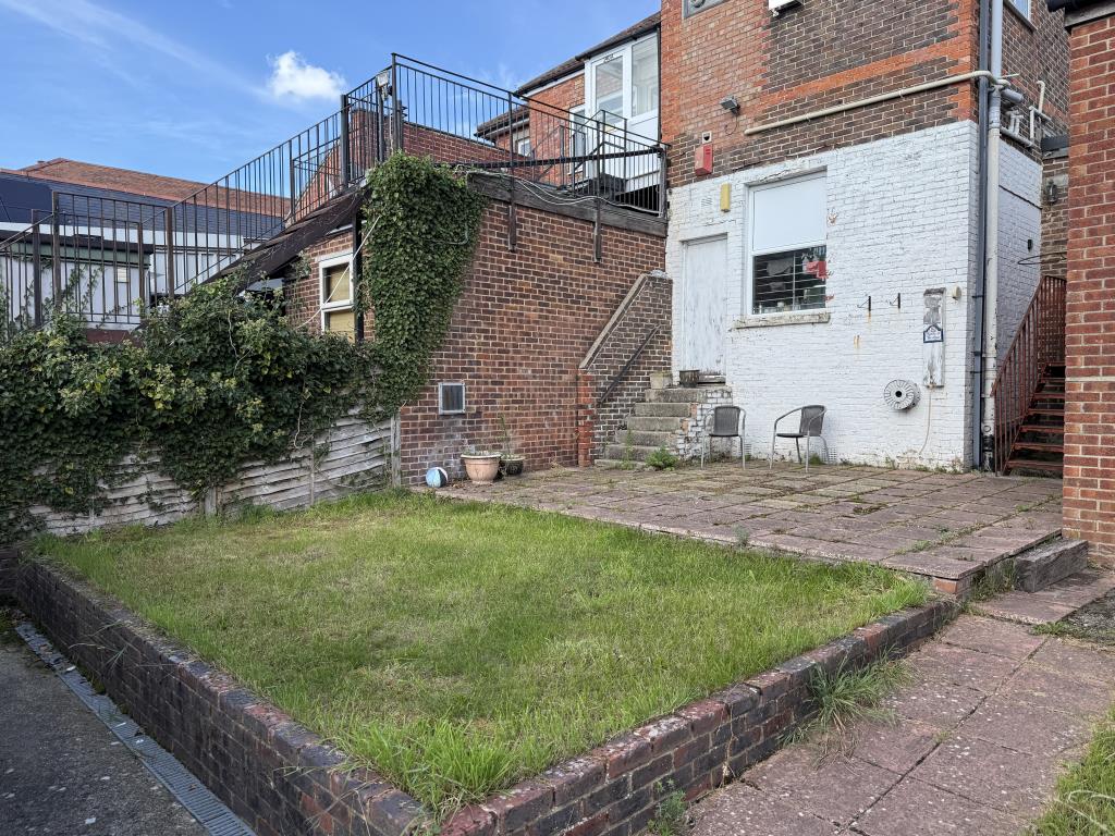 Lot: 128 - TWO-BEDROOM FLAT WITH GARAGE IN NEED OF IMPROVEMENT - Garden with patio and grass lawn
